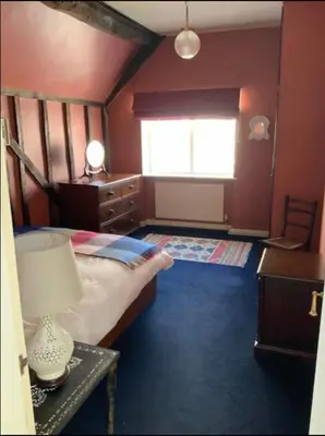 a bedroom with a bed and a table with a lamp at Magical period house in the heart of Ludlow - Pass the Keys in Ludlow