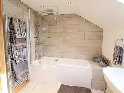 a bathroom with a white tub and a shower at Tyn Y Ceubren Bach at Evelyns Retreat in Corwen