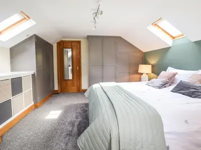a bedroom with a large white bed and skylights at Tyn Y Ceubren Bach at Evelyns Retreat in Corwen