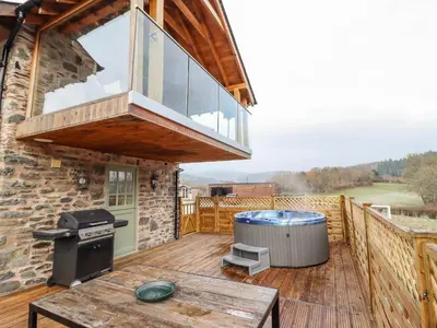 a deck with a grill and a stove on top of a house at Tyn Y Ceubren Bach at Evelyns Retreat in Corwen