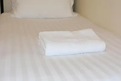 a stack of white towels sitting on a bed at Family home close to Shrewsbury Town centre in Shrewsbury
