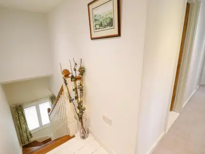 a hallway with a staircase with a picture on the wall at Tan Y Ddol in Welshpool