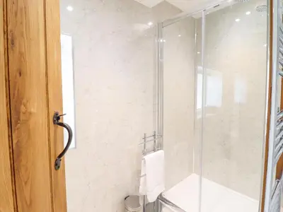 a shower with a glass door in a bathroom at Tan Y Ddol in Welshpool