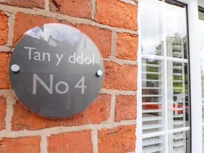 a sign on the side of a brick wall at Tan Y Ddol in Welshpool