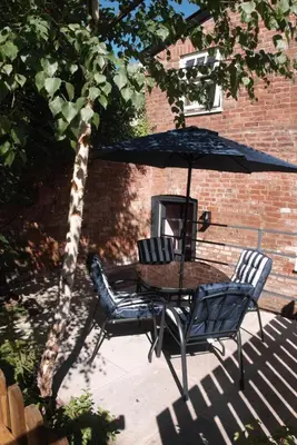 a table and chairs under an umbrella on a patio at The Gardener's Cottage in Leominster