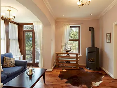 a living room with a blue couch and a wood stove at Luxury 5 bedroom Riverside home in town centre - Pass the Keys in Shrewsbury