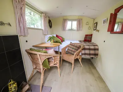 a small room with a table and chairs and a bed at Tilly Gypsy-style Caravan Hut in Brecon