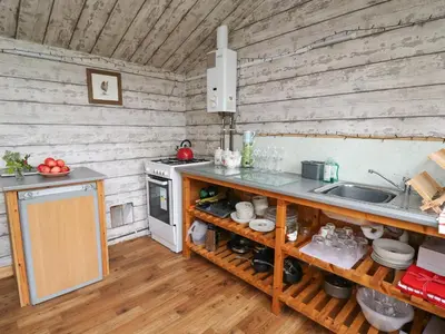 a kitchen with wooden walls and a counter with a sink at Brown Hare Shepherds Hut in Brecon