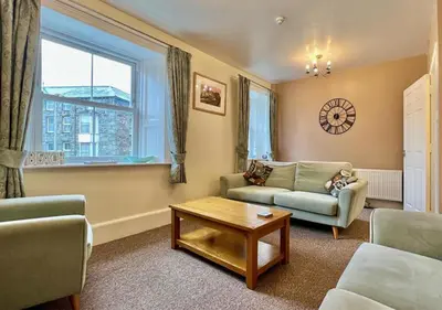 a living room with a couch and a table and a window at Luxury 4 Bedroom Seaside Apartment - Glan Y Werydd House in Barmouth