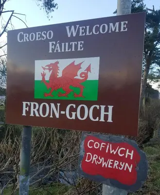 a sign for a welcome centre with a red dragon on it at Rhydydefaid Cwt Clyd - Cosy Hut in Bala
