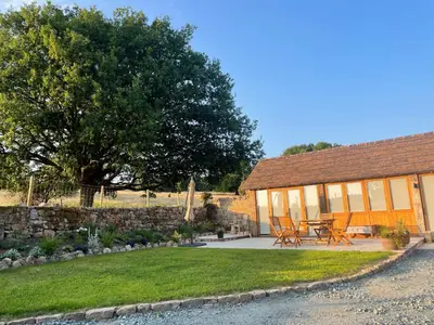 a house with a table and chairs in front of it at Beautiful countryside Byre conversion in Shrewsbury