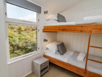 a bedroom with two bunk beds and a window at Top Of The World Lodge in Aberdyfi