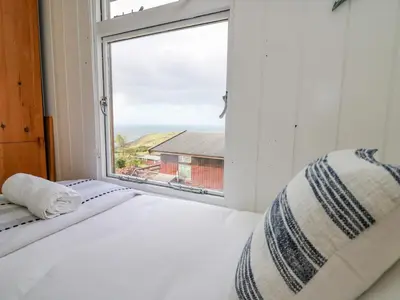 a bedroom with a bed and a large window at Top Of The World Lodge in Aberdyfi