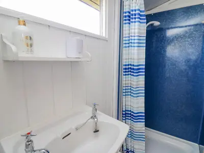 a bathroom with a sink and a shower curtain at Top Of The World Lodge in Aberdyfi