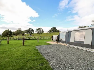 an rv parked in a field with a fence at The Otter in Rhayader