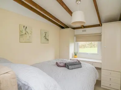 a bedroom with a white bed and a window at Riverside Rest in Builth Wells