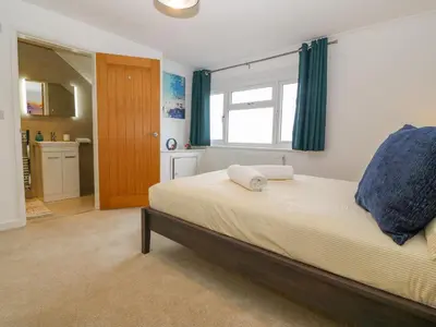 a bedroom with a bed and a window and a kitchen at Machlud Haul in Llwyngwril