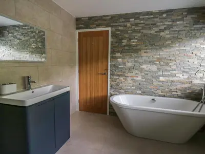 a bathroom with a white tub and a sink at Machlud Haul in Llwyngwril