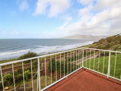 a balcony with a view of the ocean at Machlud Haul in Llwyngwril