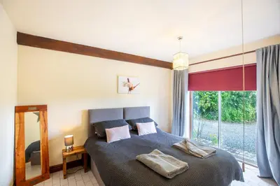 a bedroom with a bed and a large window at Owlbury Hall Barn in Montgomery