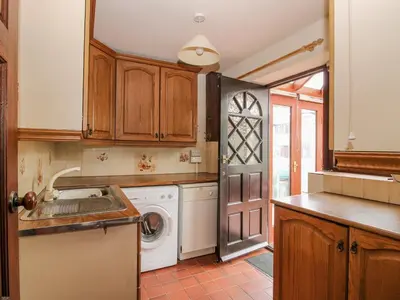 a kitchen with a washer and dryer in it at Owlbury Hall Barn in Montgomery
