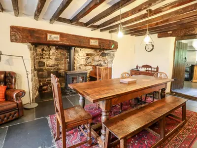 a dining room with a wooden table and chairs at Gwengraig in Dolgellau