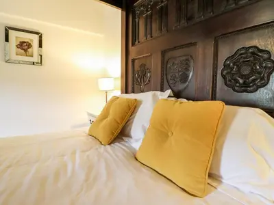 a bedroom with a large bed with yellow pillows at Gwengraig in Dolgellau