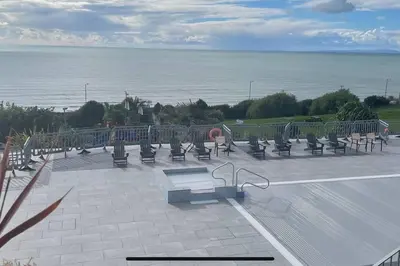 a row of benches sitting next to the water at Barmouth Pet-Friendly 2-Bed Caravan with Sea View in Barmouth
