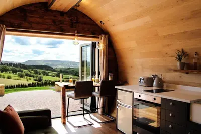 a kitchen with a table and a large window at Burrow View in Rhayader