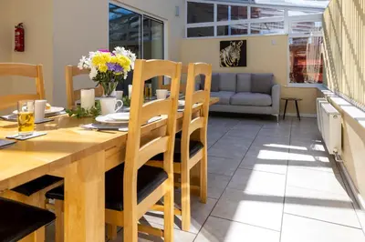a kitchen and dining room with a wooden table and chairs at Fair View - Off Street Parking and Garden in Shrewsbury