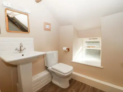 a white bathroom with a sink and a toilet at Tyn Llwyn in Talsarnau