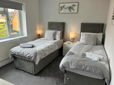 a bedroom with two beds next to a window at Fair Haven - Off Street Parking and Garden in Shrewsbury