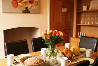a table with a vase of flowers and bread at Pet-Friendly Logburner Horse Stable Views in Hay-on-Wye