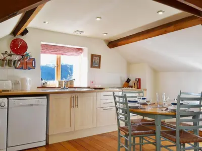 a kitchen with a table and chairs and a sink at Stable Cottage in Oswestry
