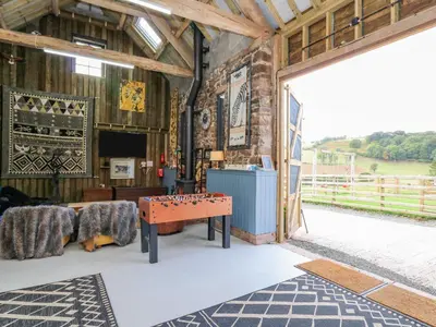 a room with a ping pong table in a barn at Pen Bont Home Farm in Brecon