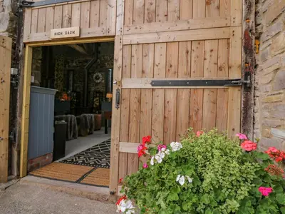 an entrance to a wooden garage with a wooden gate at Pen Bont Home Farm in Brecon