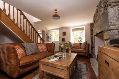 a living room with a couch and a table at Charming Riverside Cottage in Snowdonia National Park in Tanygrisiau