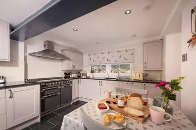 a kitchen with a table with bread on it at Charming Riverside Cottage in Snowdonia National Park in Tanygrisiau