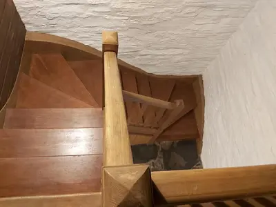 an overhead view of a wooden spiral staircase in a building at Longhouse - Y Beudy in Rhayader