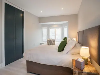 a bedroom with a large bed with green pillows at Dau Ddeg in New Quay