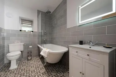 a bathroom with a toilet and a tub and a sink at Luxurious Riverside Cottage in Snowdonia National Park in Tanygrisiau