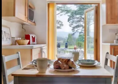 a kitchen with a table with a plate of food on it at Mountain View Cottage, Hot Tub , Stunning Views in Llanhamlach