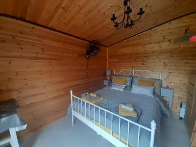 a bedroom with a bed in a wooden cabin at The Hut B & B in Mochdre