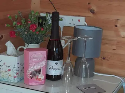 a bottle of wine and two glasses on a table at The Hut B & B in Mochdre