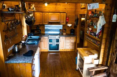 an overhead view of a kitchen with wooden floors and cabinets at George Cabin - Log Cabin in Wales with Hot tub in Newtown
