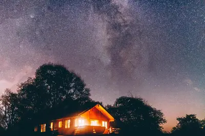 a cabin under a night sky with a star filled sky at George Cabin - Log Cabin in Wales with Hot tub in Newtown