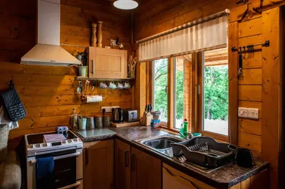 a kitchen with a sink and a stove at Cherry Cabin - Little Log Cabin in Wales in Bettws Cedewain