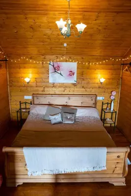 a bedroom with a large bed in a wooden room at Blossom Cabin - Little log Cabin in Wales in Newtown