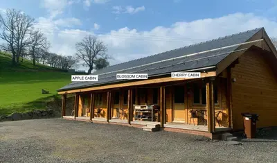 a building with signs on the front of it at APPLE Cabin - Little Log Cabin in Wales in Newtown