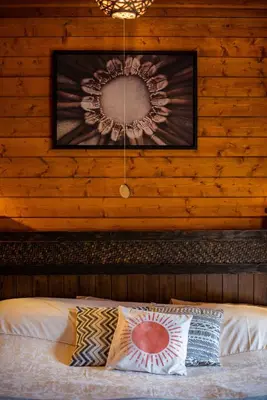 a bedroom with a bed with a mirror on the wall at APPLE Cabin - Little Log Cabin in Wales in Newtown